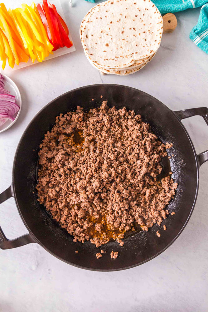 Ground beef cooking in a skillet to make ground beef fajitas.