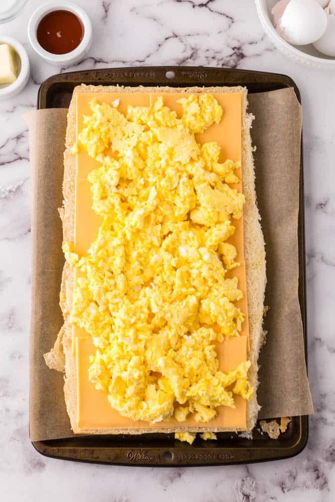 Hawaiian roll breakfast sliders layered with eggs and cheese.