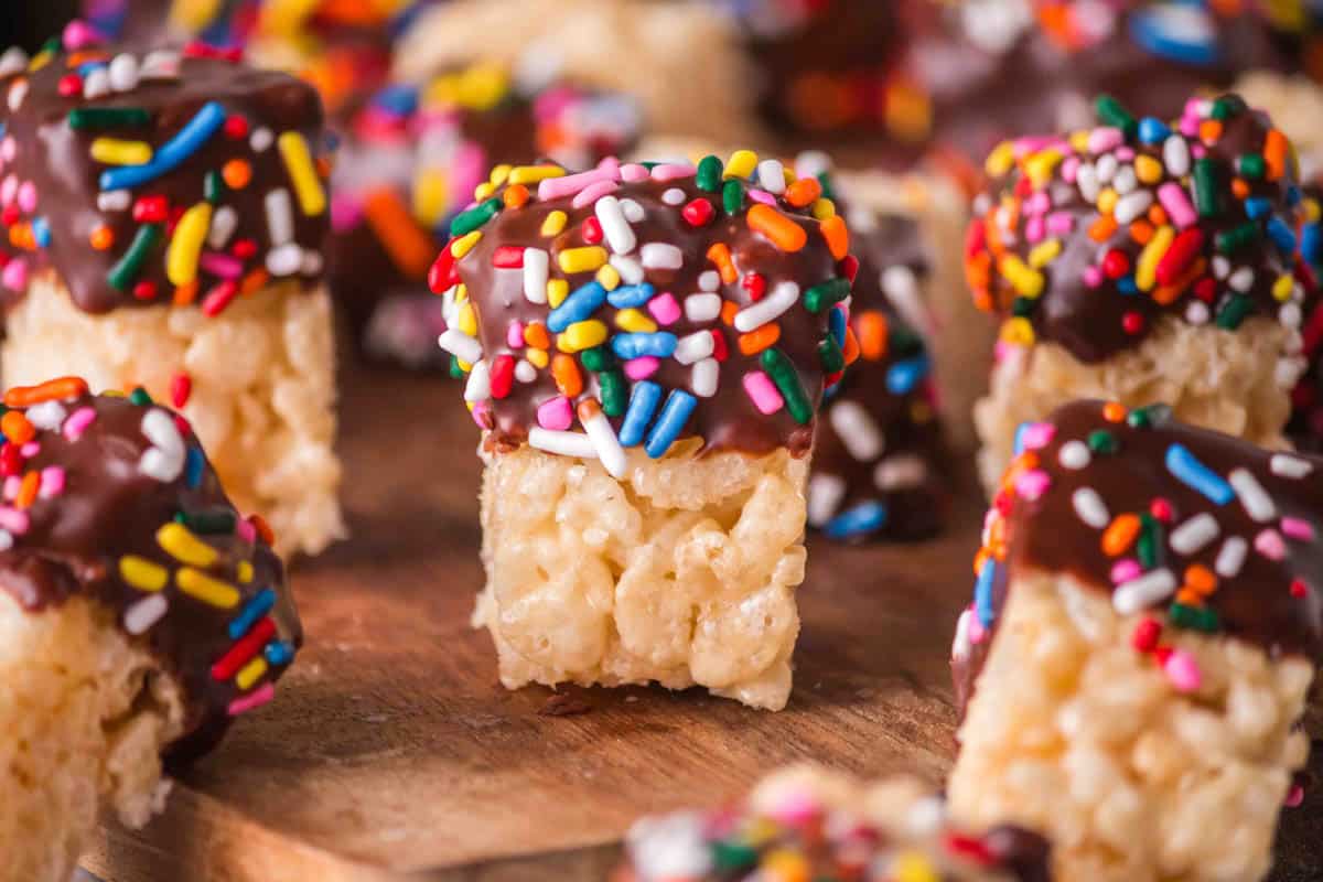 Close up of small pieces of chocolate dipped rice krispie treats.