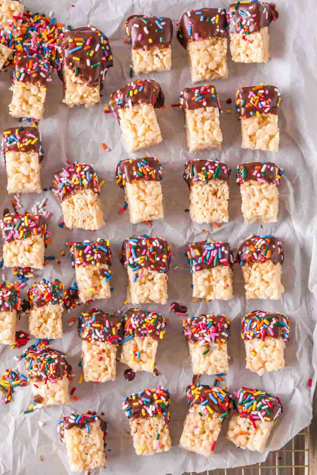 Rice Krispie treats dipped in chocolate and covered with sprinkles. 