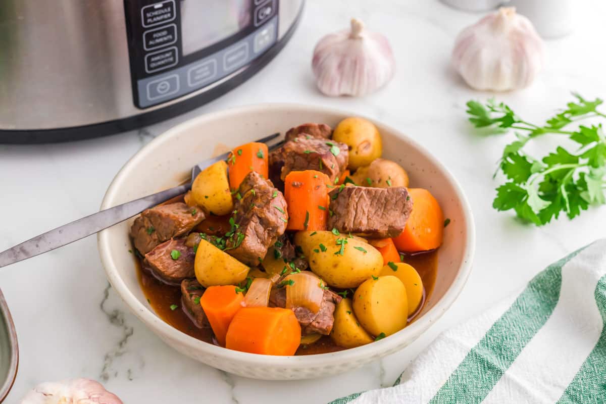 Slow cooker Irish stew with guinness in a white bowl. 