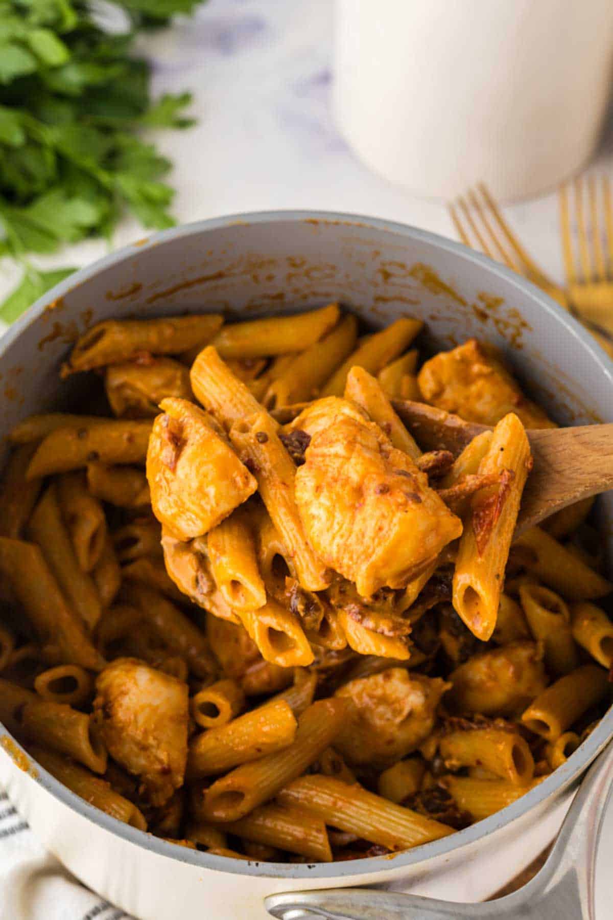 Spicy chipotle chicken pasta on a wooden spoon.