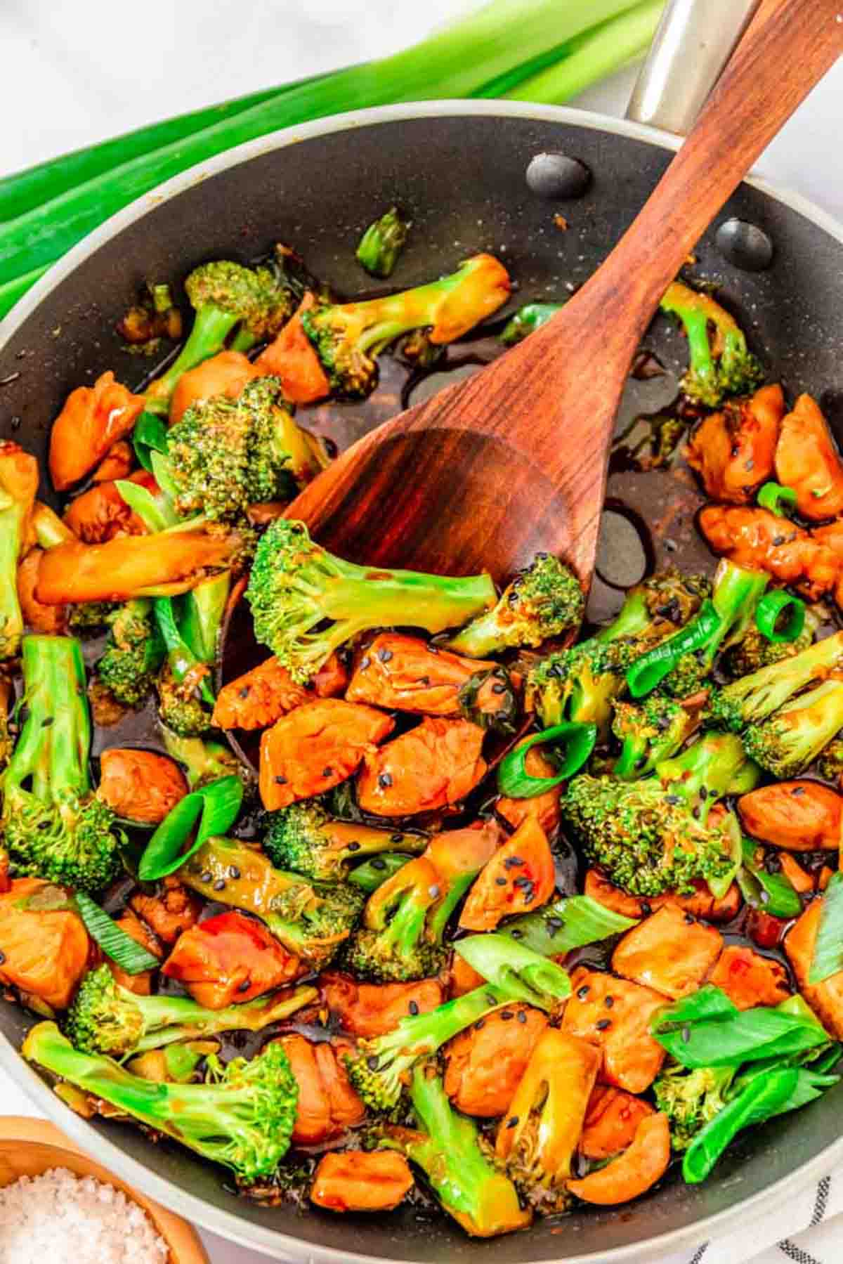 Easy Teriyaki chicken with broccoli in a pan with a wooden spoon.