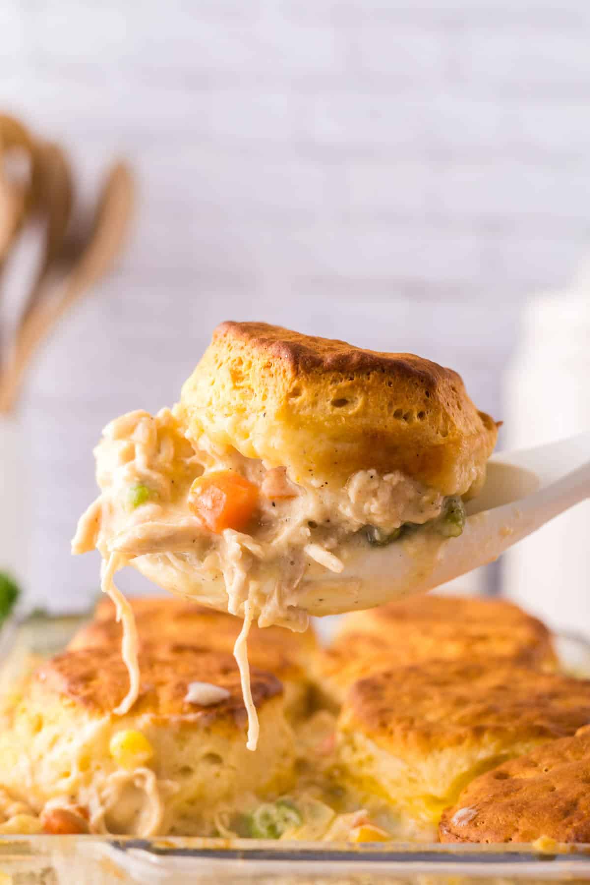 Easy Chicken Pot Pie Casserole with Biscuits on a large spoon.