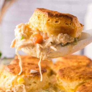 Easy Chicken Pot Pie Casserole with Biscuits on a large spoon.