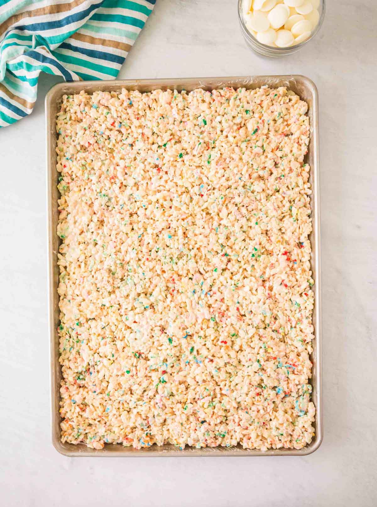 Rice Krispie Treats with Sprinkles pressed flat onto a baking sheet.