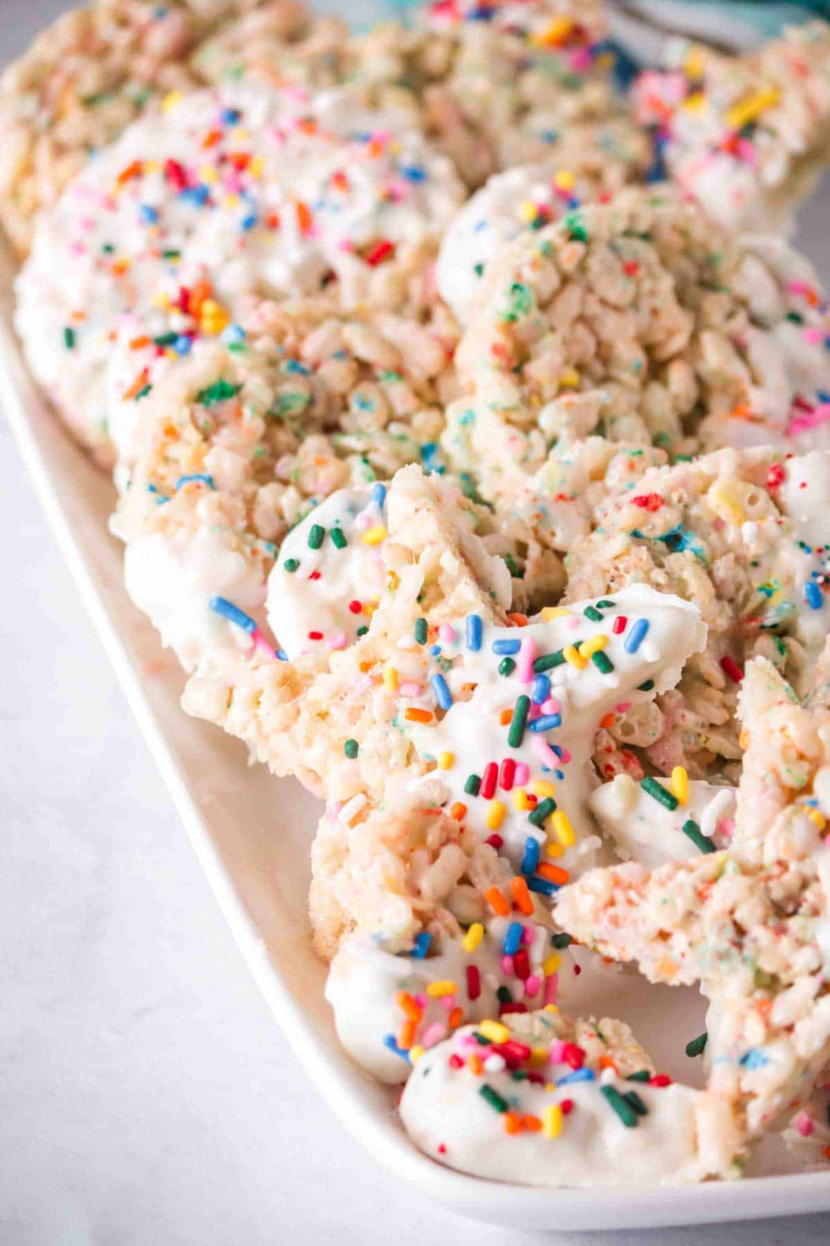 Funfetti rice krispie treats with sprinkles cut into shapes on a plate.