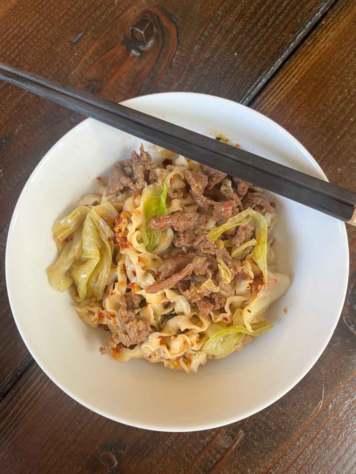 Trader Joe's Beef Bulgogi Stir fry with squiggly  noodles in a white bowl.