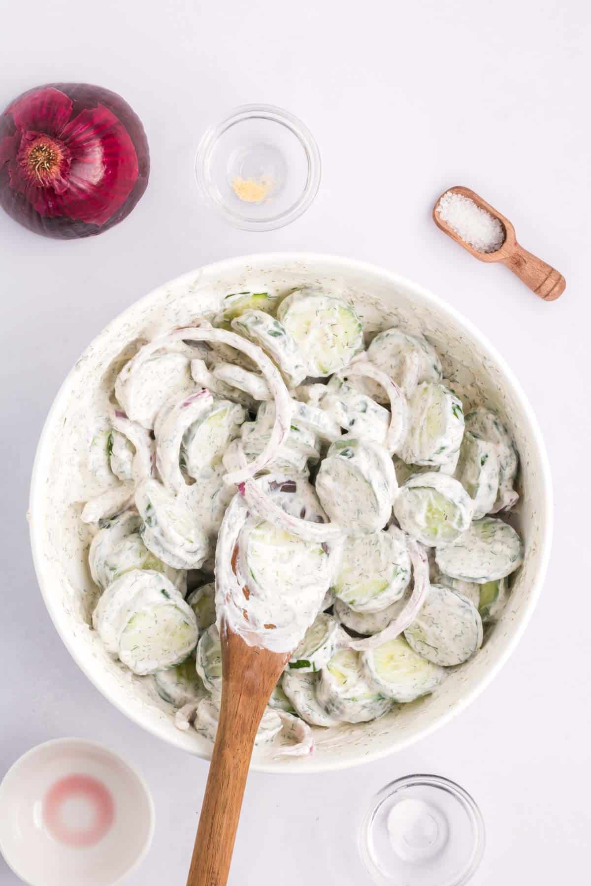 Last step when making creamy cucumber salad with mayo is to toss everything in a large bowl.