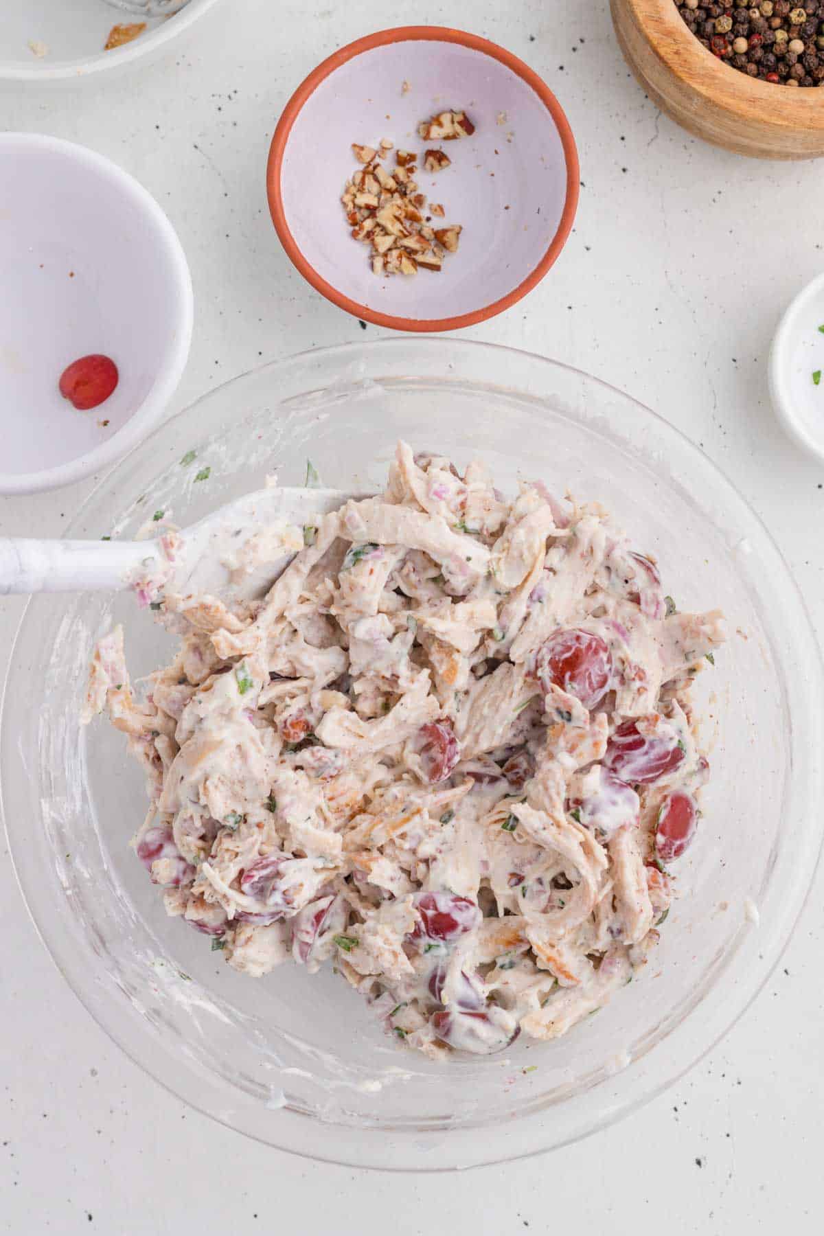 Chicken being tossed in the dressing.