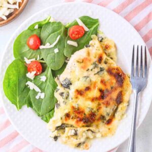 Trader Joe's Spinach and Artichoke dip chicken on a plate with spinach salad.