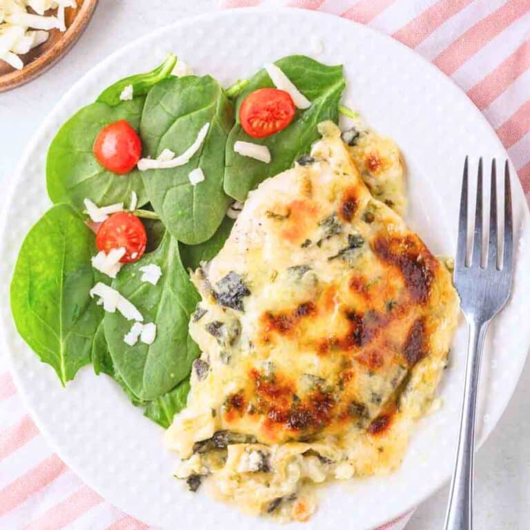 Trader Joe's Spinach and Artichoke dip chicken on a plate with spinach salad.