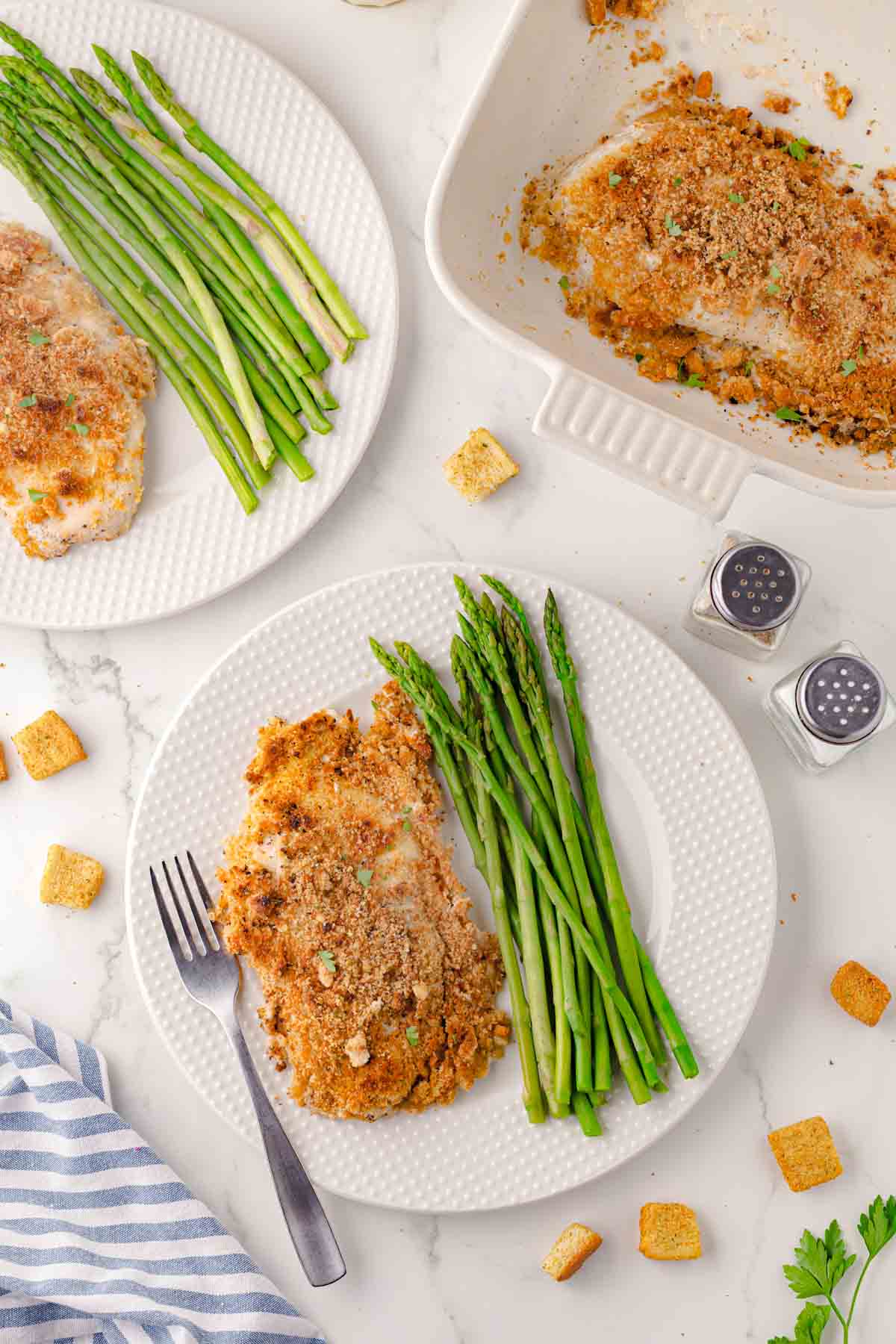 Caesar chicken bake on a plate with asparagus.