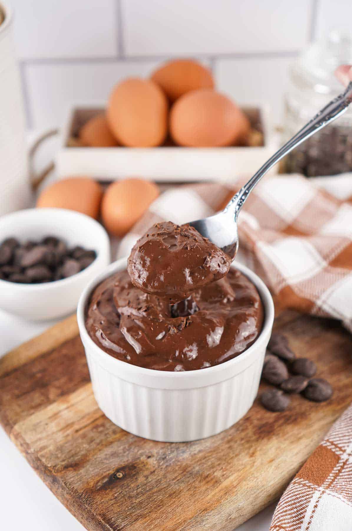 Viral egg chocolate pudding in a white dish with a spoon.